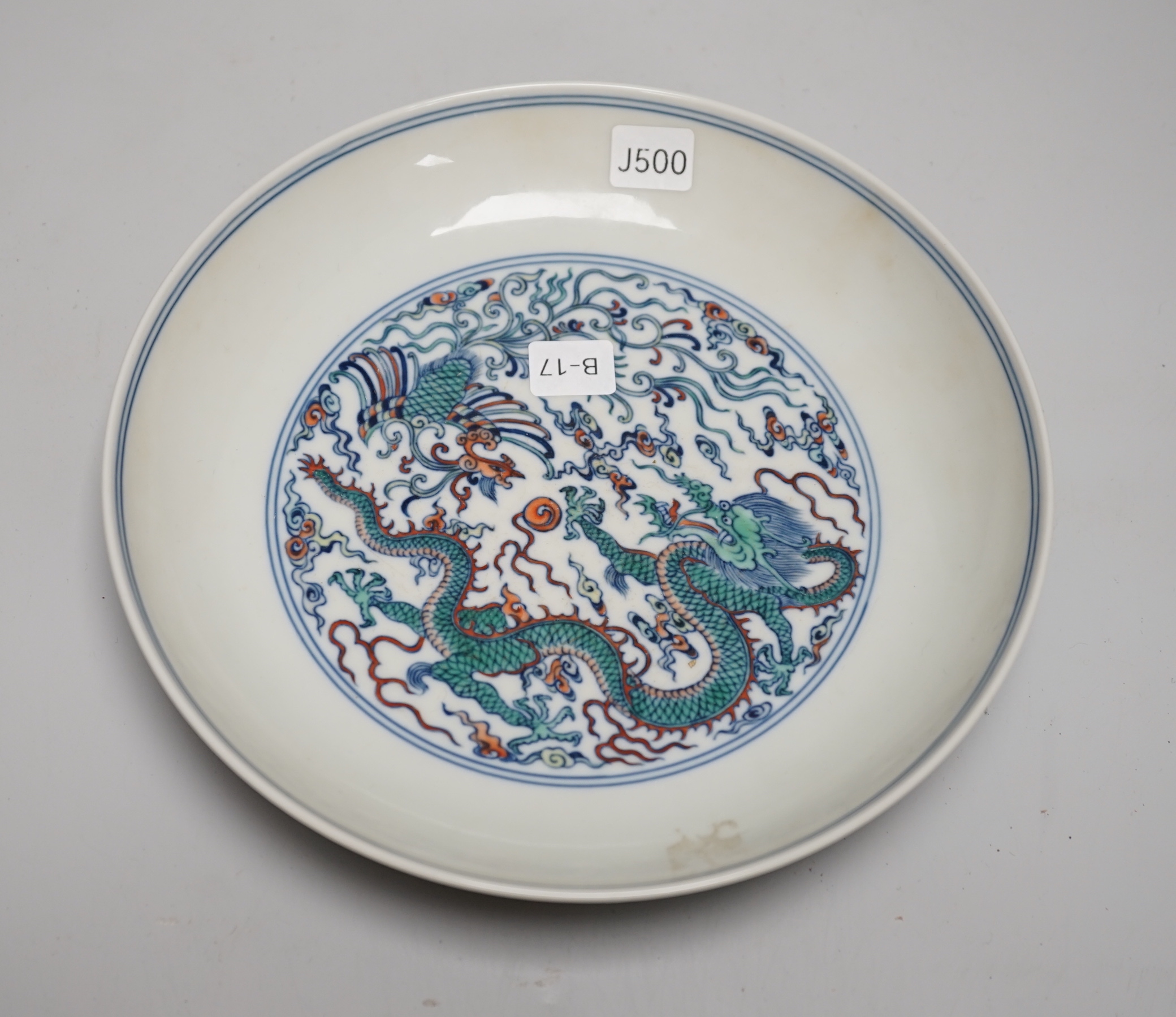A Chinese doucai dish hand painted with a dragon chasing the flaming pearl, housed in a fitted case, 20cm in diameter